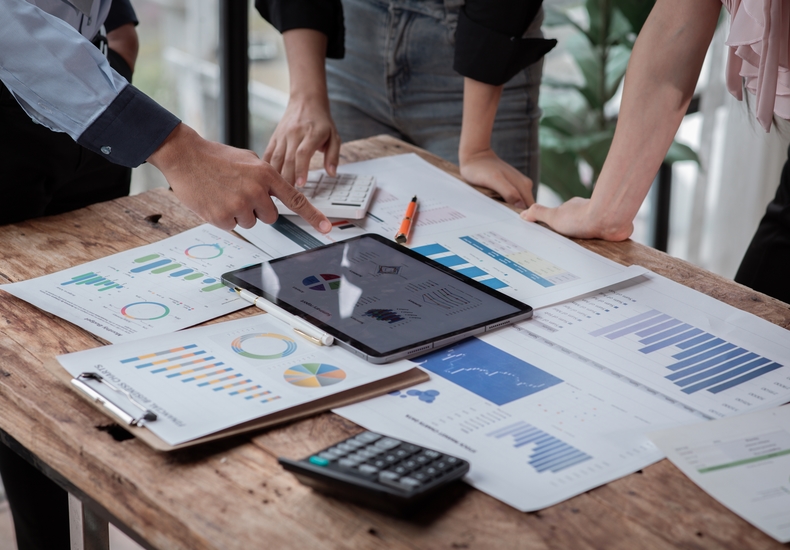 Team analysiert Daten auf Tablet mit Diagrammen und Berichten – Symbol für strategische Netzwerkoptimierung und Investitionssicherheit