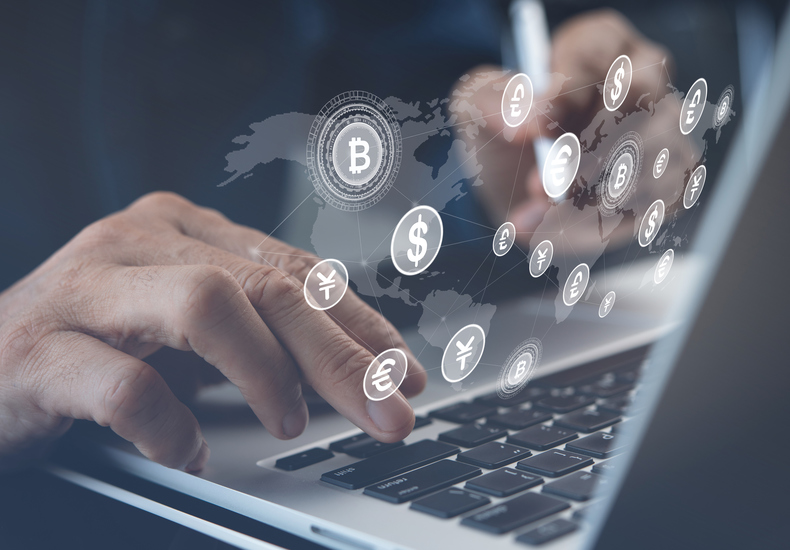 Geschäftsperson tippt auf Laptop mit digitalen Währungssymbolen, symbolisiert Fördermittel, Finanzierungen und Nachhaltigkeitszertifizierungen.